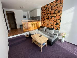 a living room with a couch and a wooden table at Apartmány Kubova Huť in Kubova Huť