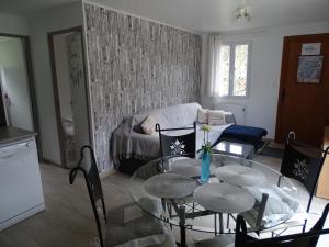 uma sala de estar com uma mesa de vidro e cadeiras em Maison Cancela em Siguer