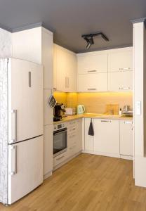 a kitchen with white cabinets and a refrigerator at Vili's Place - 1 Bedroom Apartment with Balcony in Varna City