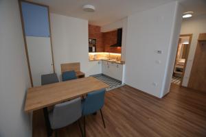 a kitchen and dining room with a wooden table and chairs at Bíbor Apartman in Sárvár