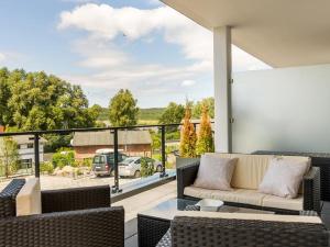 d'une terrasse avec un canapé et des chaises sur un balcon. dans l'établissement Residenz Seeterrassen Appartment Nr. 1, à Binz