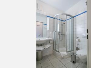 La salle de bains est pourvue d'une douche, de toilettes et d'un lavabo. dans l'établissement Kaiservillen Heringsdorf - 1-Raum-Ferienwohnung mit Balkon D113, à Heringsdorf