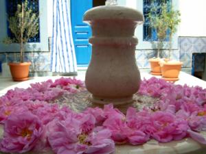 a vase and pink flowers on a table at Dar Baaziz in Sousse