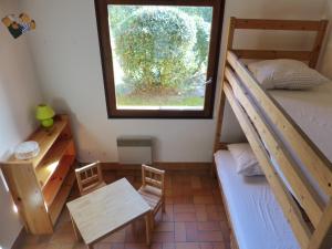 um quarto com um beliche, uma mesa e uma janela em La Maison Des Moineaux Entre Lac Et Ocean Pour 6 Personnes em Hossegor