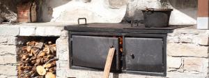 einen alten Backsteinofen mit einem Topf oben in der Unterkunft Sole - Casa Azzurra Piano Terra in Livigno