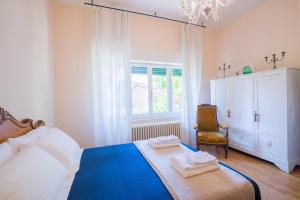 una camera con un letto e una sedia e una finestra di Casa con Giardino a 100 metri dal centro storico a Lucignano
