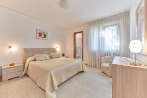 a bedroom with a bed and a chair and a window at Residence La Cioca in Malcesine