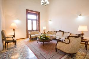 sala de estar con sofá, sillas y mesa en Hotel Senorial, en Querétaro