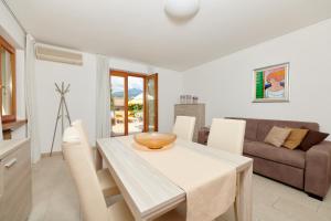 a white dining room with a table and chairs at Residence La Cioca in Malcesine