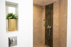 a shower with a wooden door in a bathroom at Metropole Apartments Old Center in Bucharest +44 photos