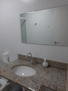 y baño con lavabo y espejo. en Apartamento Braga, en Cabo Frío