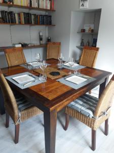 uma mesa de madeira com cadeiras e copos de vinho em Escale Au Chiteau em Huisseau-sur-Cosson