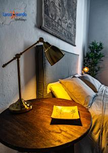 a table with a lamp and a book on it next to a bed at Vivienda Vacacional El Patio de Franky in Teguise