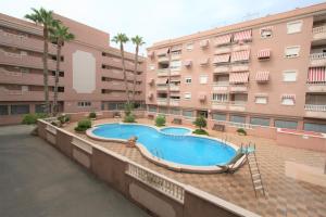 a swimming pool in front of a building at 042 - Las Marismas I - 002 comfortHOLIDAYS in Santa Pola