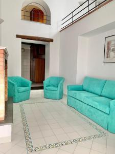 ein Wohnzimmer mit einem blauen Sofa und 2 Stühlen in der Unterkunft Antico Palazzo Scala in Sorrent