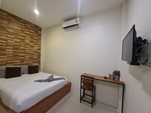 a bedroom with a bed and a flat screen tv at Samed Your House in Ko Samed