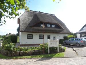 a small white house with a thatched roof at Ferienhaus Möwe in Lancken-Granitz