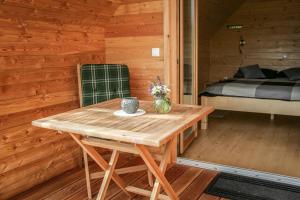 a wooden table and chairs in a room with a bed at Glamping Kranjc in Kobarid