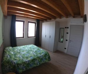 ポンティ・スル・ミンチョにあるAgriturismo Ai Tre Fieniliのベッドルーム(ベッド1台、窓付)