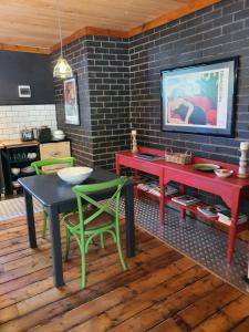 a dining room with red and green tables and chairs at Shepherd's Cottage in Nieu-Bethesda