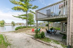 a house with a deck and a table and chairs at Beach1 Riverfront Resort in Wasaga Beach