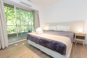 a bedroom with a large bed and a large window at Babel Belgrano in Buenos Aires