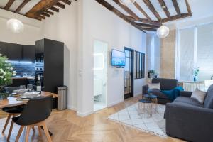 - un salon avec un canapé et une table dans l'établissement GemBnB Luxury Apartments - Residence Timbaud Paris-Oberkampf, à Paris