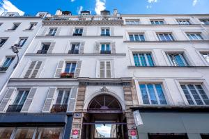un gran edificio blanco con ventanas y puerta en GemBnB Luxury Apartments - Residence Timbaud Paris-Oberkampf, en París
