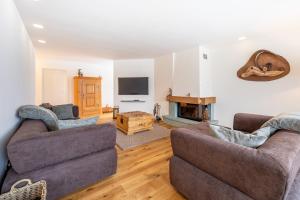 sala de estar con 2 sofás y chimenea en LAAX Homes - Val Signina 7-12, en Laax