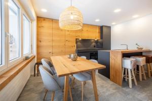 Il comprend une cuisine et une salle à manger avec une table et des chaises en bois. dans l'établissement LAAX Homes - Val Signina 7-12, à Laax