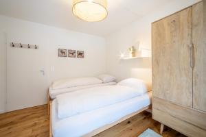 Habitación con cama y armario de madera. en LAAX Homes - Val Signina 7-12, en Laax