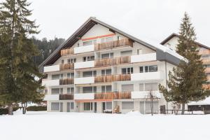 un edificio con nieve delante en LAAX Homes - Val Signina 7-12, en Laax