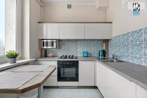 a kitchen with white cabinets and a counter top at MS Apartments Centrum Gdyni I in Gdynia