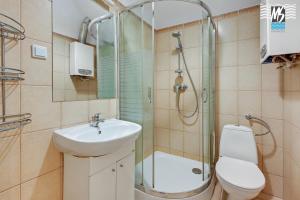 a bathroom with a shower and a sink and a toilet at MS Apartments Centrum Gdyni I in Gdynia