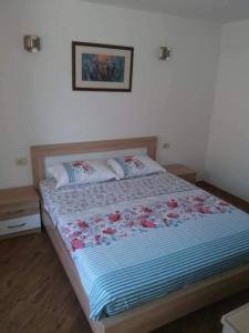 una camera da letto con un grande letto con fiori di Olive tree apartments a Tivat