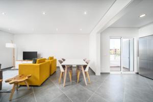 een woonkamer met een tafel en een gele bank bij Modern Stylish 2 Bedroom Apartment, Close to Amenities, Cabanas in Cabanas de Tavira