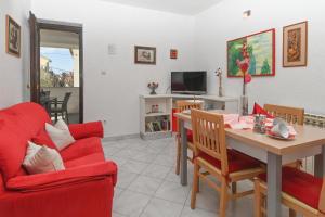 a living room with a red couch and a table at Apartments Sunčica in Mali Lošinj