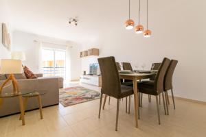 - un salon avec une table, des chaises et un canapé dans l'établissement Family Holiday Home, Vale de Parra, Albufeira, à Galé