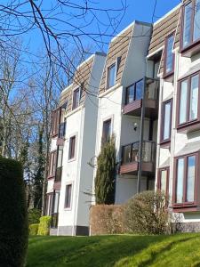 un edificio de apartamentos con un césped verde delante de él en Gleneagles Luxury Apartments, en Auchterarder