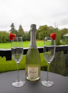 Una botella de vino y dos copas en una mesa. en Gleneagles Luxury Apartments en Auchterarder