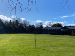 two trees in a field with a building in the background at Gleneagles Luxury Apartments in Auchterarder +5 photos