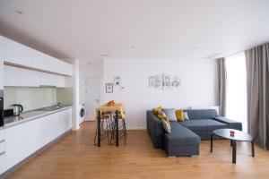 salon z niebieską kanapą i kuchnią w obiekcie Afthonia Apartamente Mamaia Nord w mieście Năvodari
