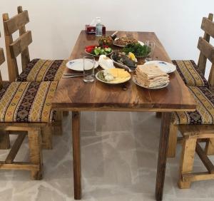 a wooden table with plates of food on it at Bjnihouse, guest house in Bjni