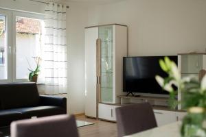 a living room with a flat screen tv sitting on a cabinet at Ferienwohnung Donau in Balingen