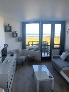 a living room with a couch and a table at Les Marinas Port Deauville in Deauville