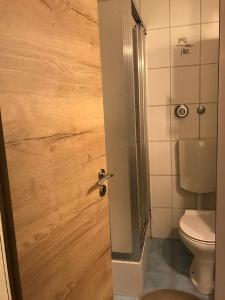 ein Badezimmer mit einem WC und einer Holztür in der Unterkunft Apartment am Bikepark mit Kamin und Sauna in Winterberg