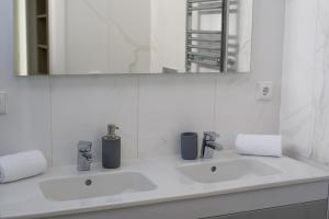 Baño blanco con 2 lavabos y espejo en Luxury Villa Aleana, en Portimão