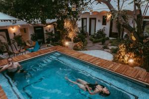 two people are swimming in a swimming pool at Amaia Boutique Hotel in Sayulita