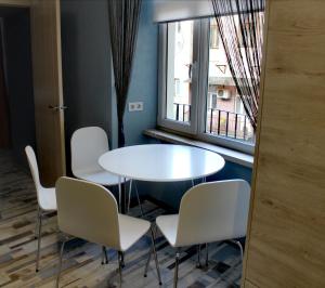 利沃夫Apartment in blue в історичному центрі міста的有窗户的房间里有一张桌子和几把椅子 更多19张照片