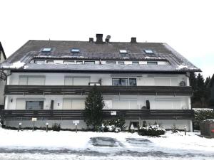 ein großes weißes Gebäude mit Schnee davor in der Unterkunft Apartment am Bikepark mit Kamin und Sauna in Winterberg